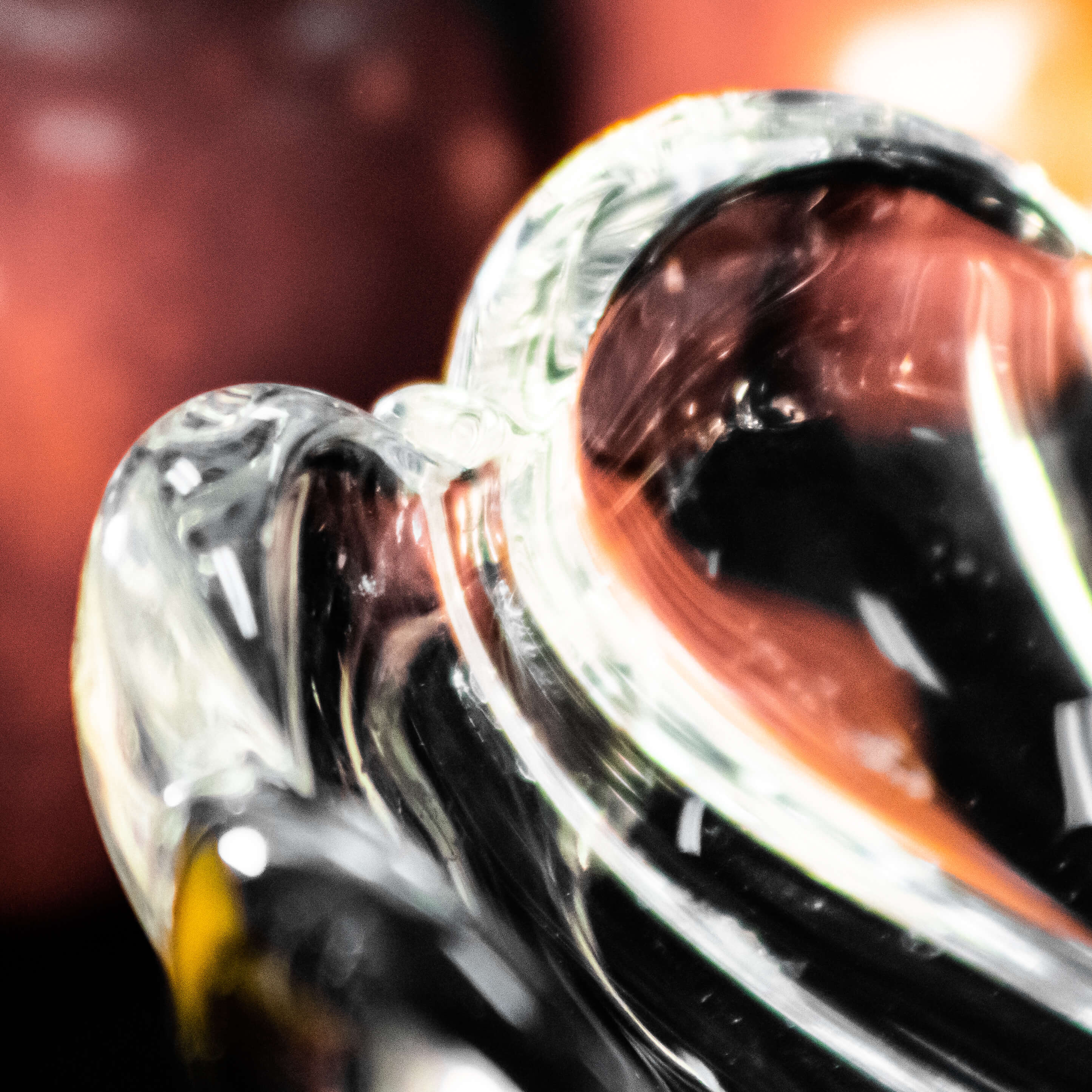 A photograph of a glass bowl in front of some apples